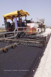 Image du Maroc Professionnelle de  Travaux sur la voie en construction Sidi el Yamani-Asilah installation de la première épaisseur de la couche de revêtement de la chaussée, Mercredi 12 Juin 2002. (Photo / Abdeljalil Bounhar)